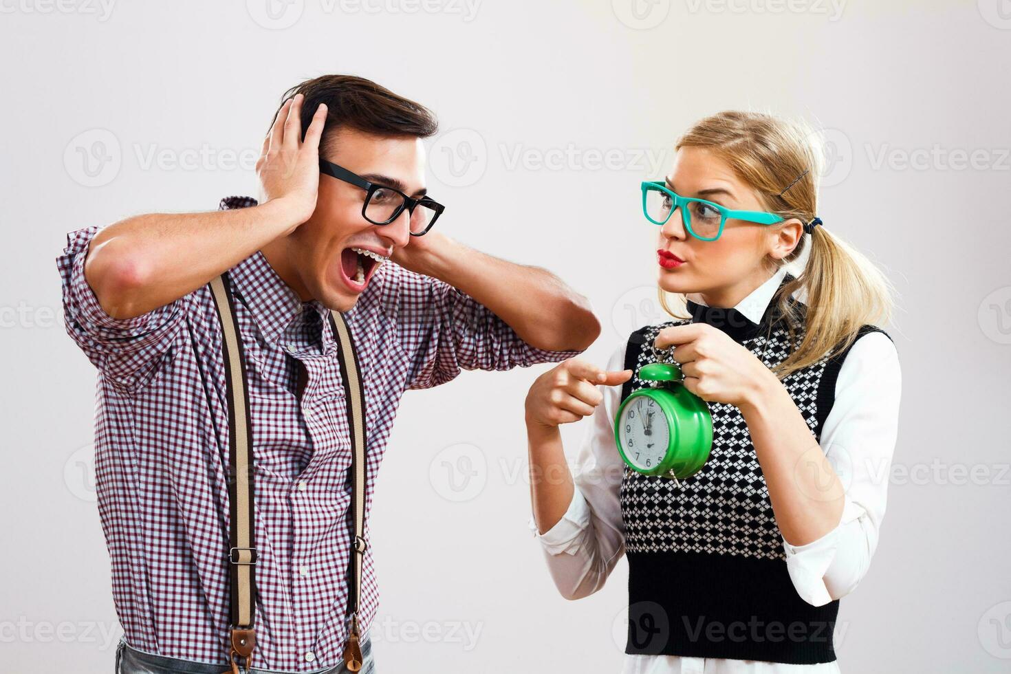 Nerdy woman showing clock to her nerdy boyfriend photo