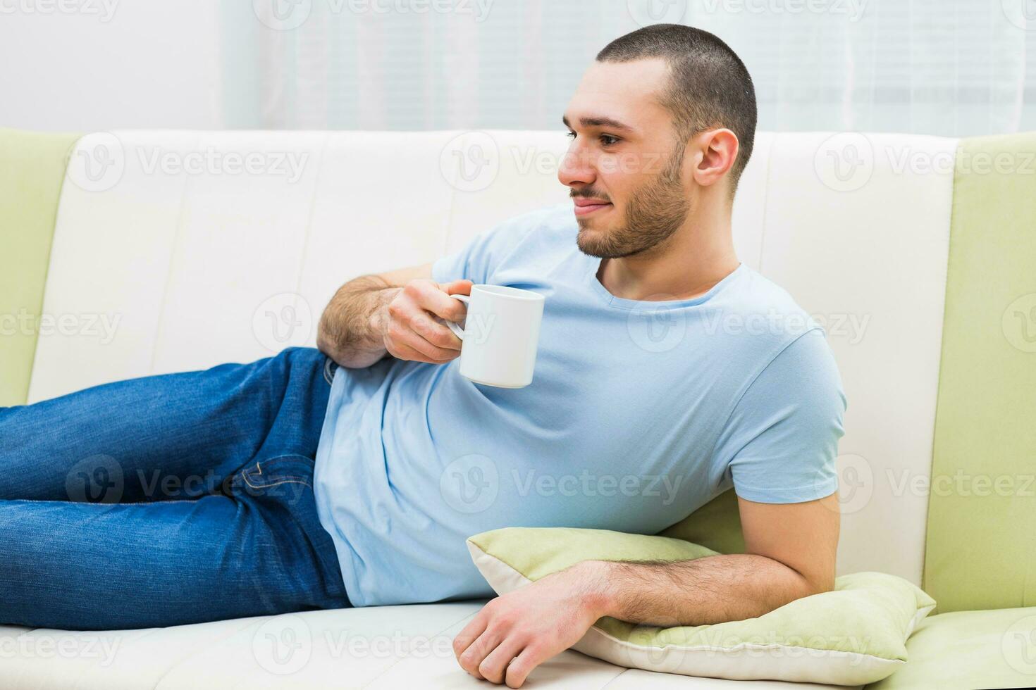 Young man enjoys drinking coffee at home photo