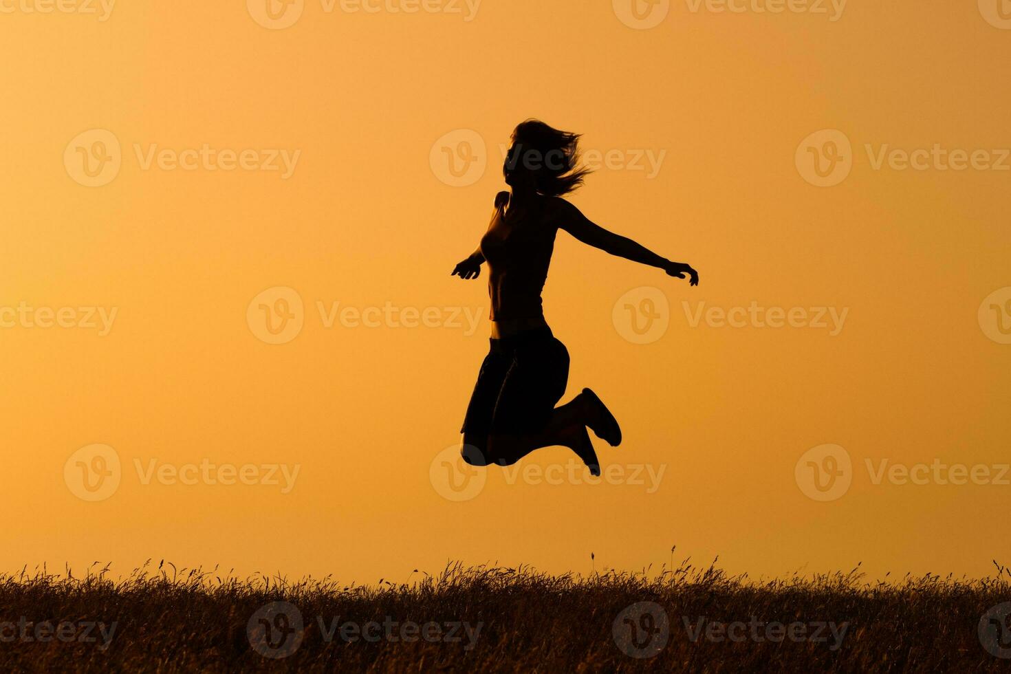 Silhouette of happy  woman jumping in the nature photo