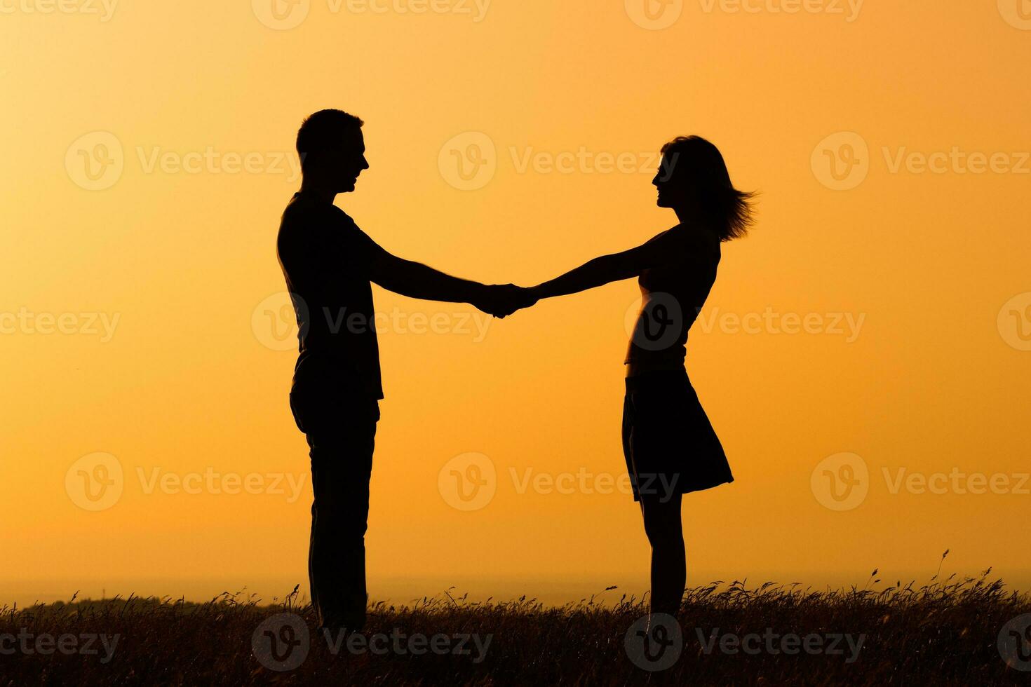 Silhouette of a man and a woman holding hands photo