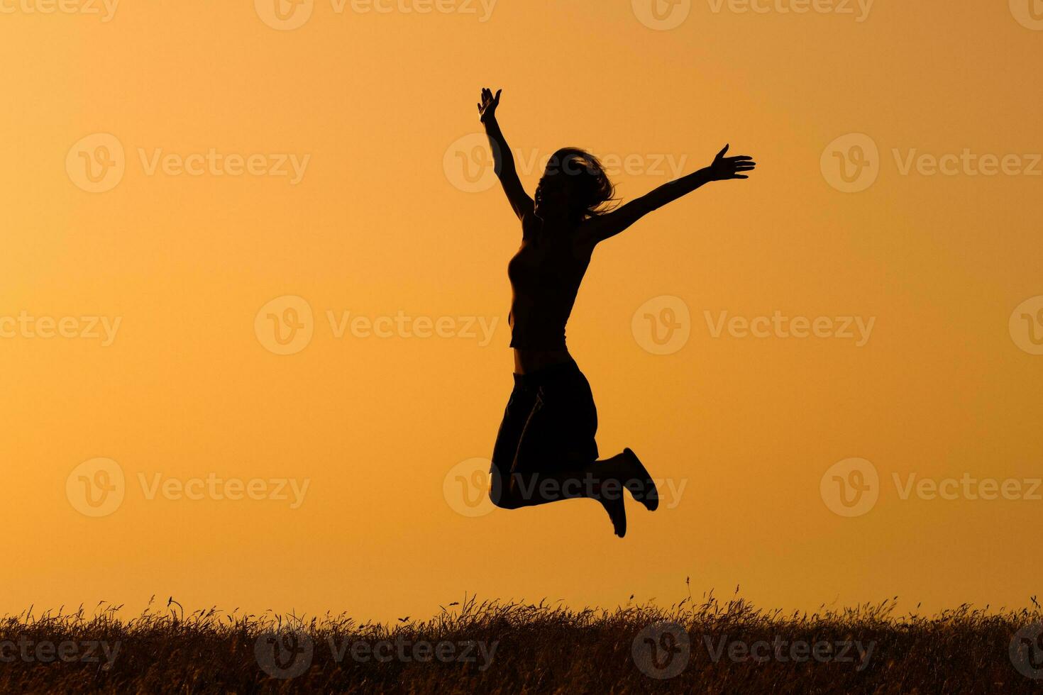 Silhouette of happy  woman jumping in the nature photo