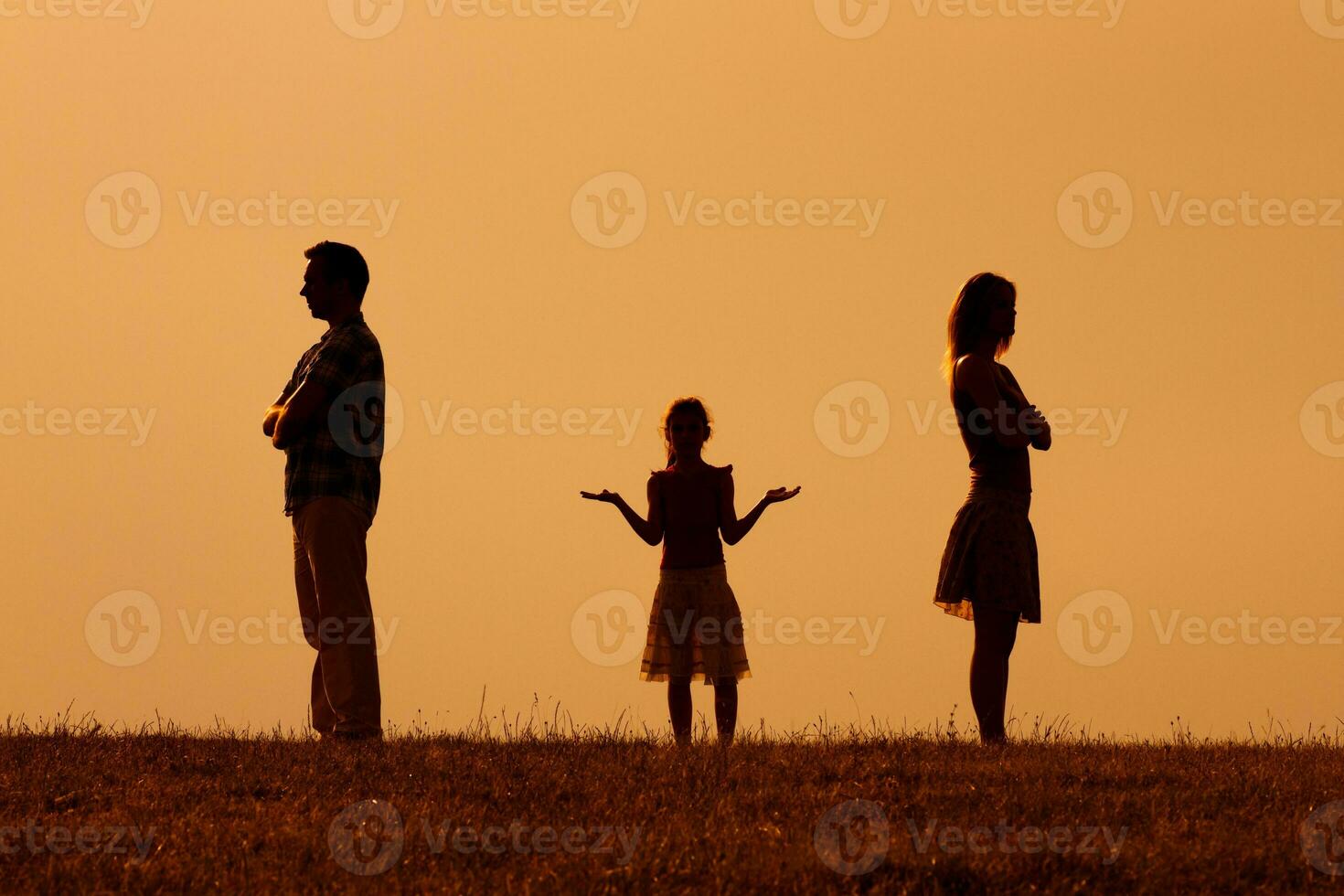 Silhouette of a angry husband and wife on each other with their confused daughter standing in the middle photo