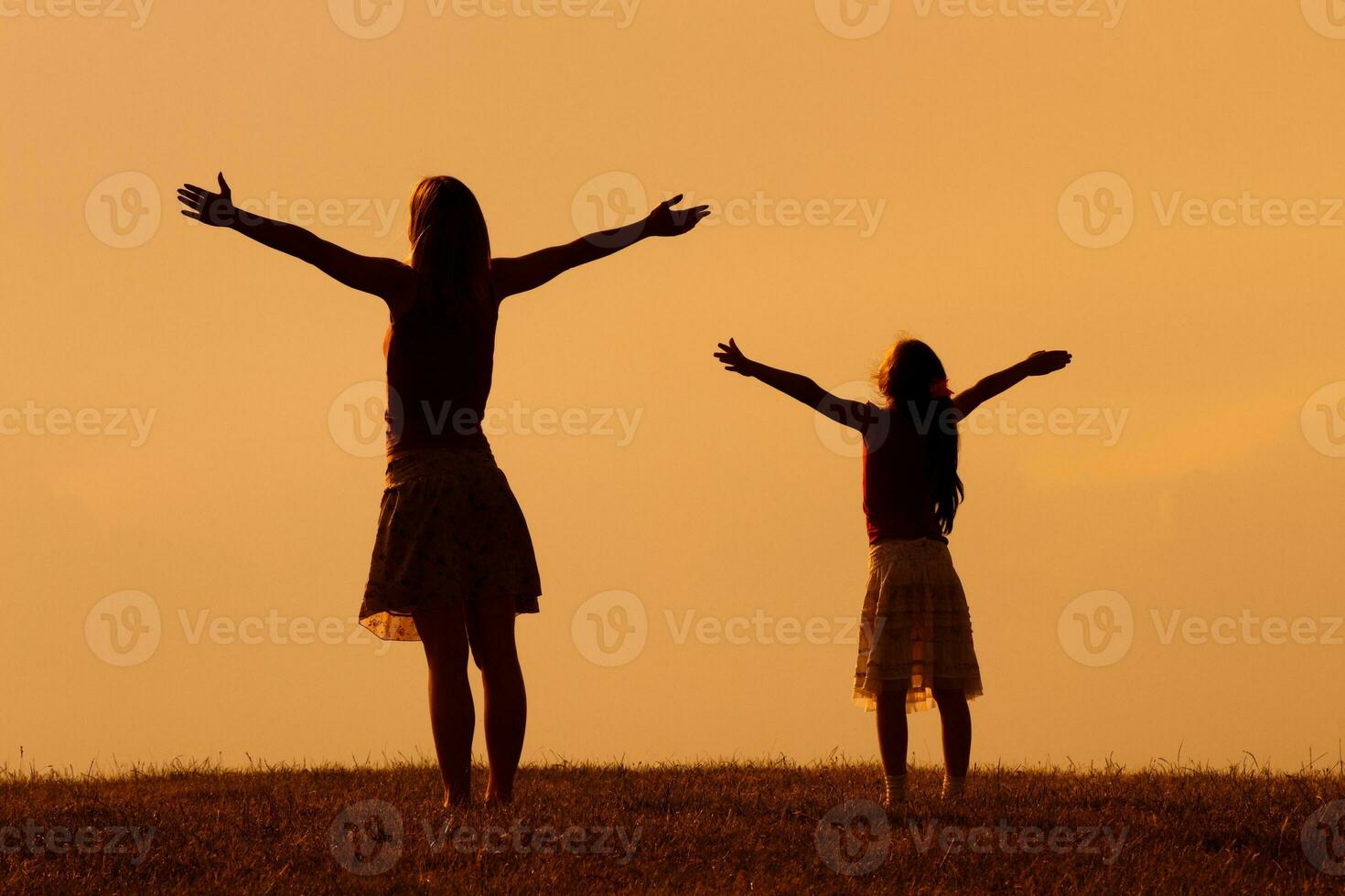 Mother and daughter greeting the sunset photo