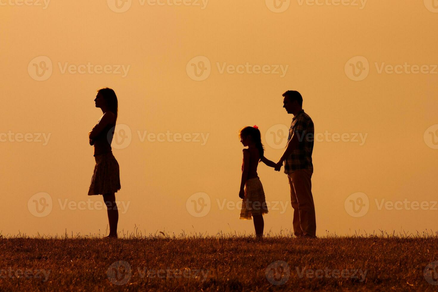 Silhouette of a angry wife turning back while her husband and daughter are looking at her photo