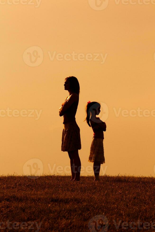 silueta de un enojado madre y hija en cada otro foto