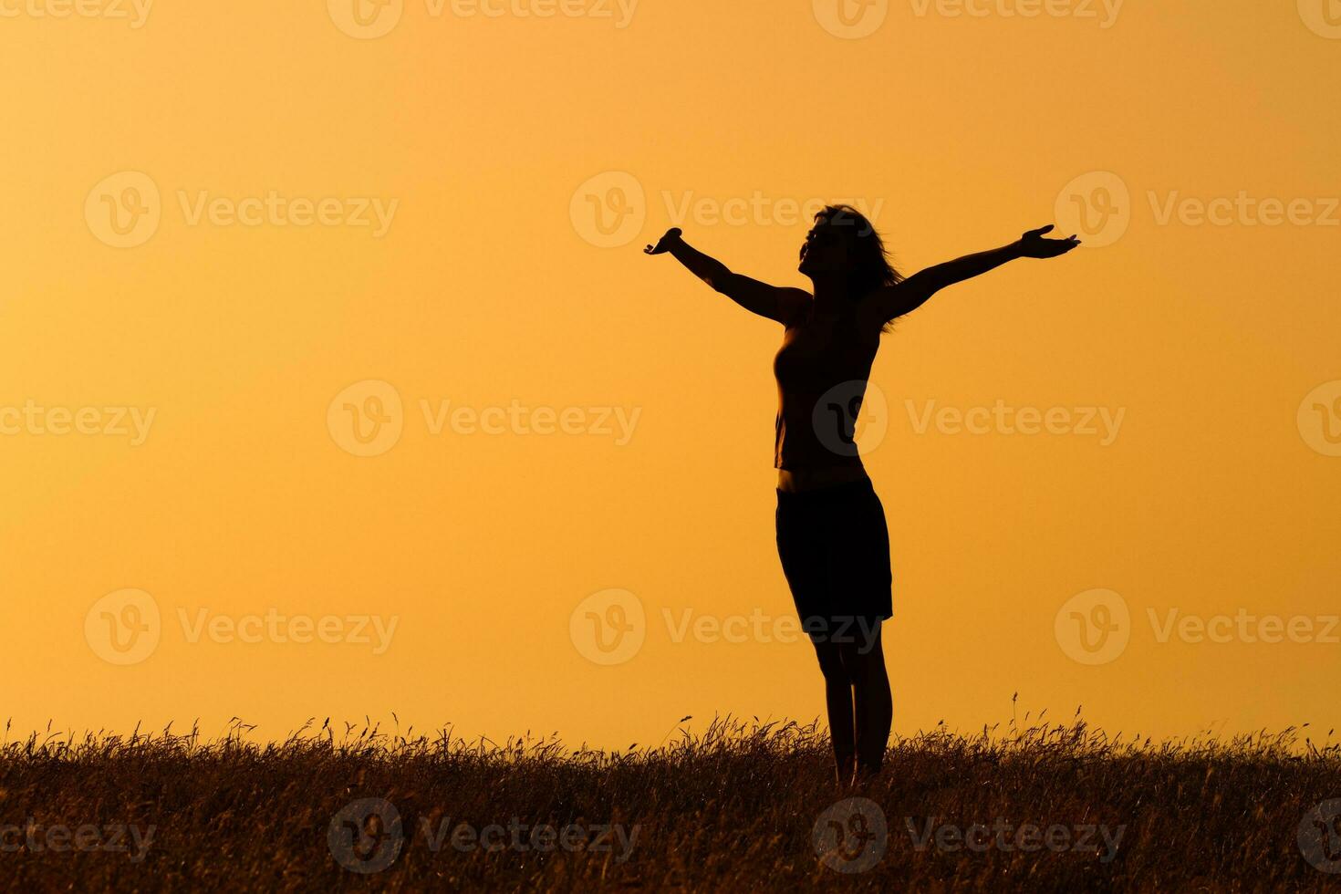 Silhouette of a  woman with her arms  outstretched photo