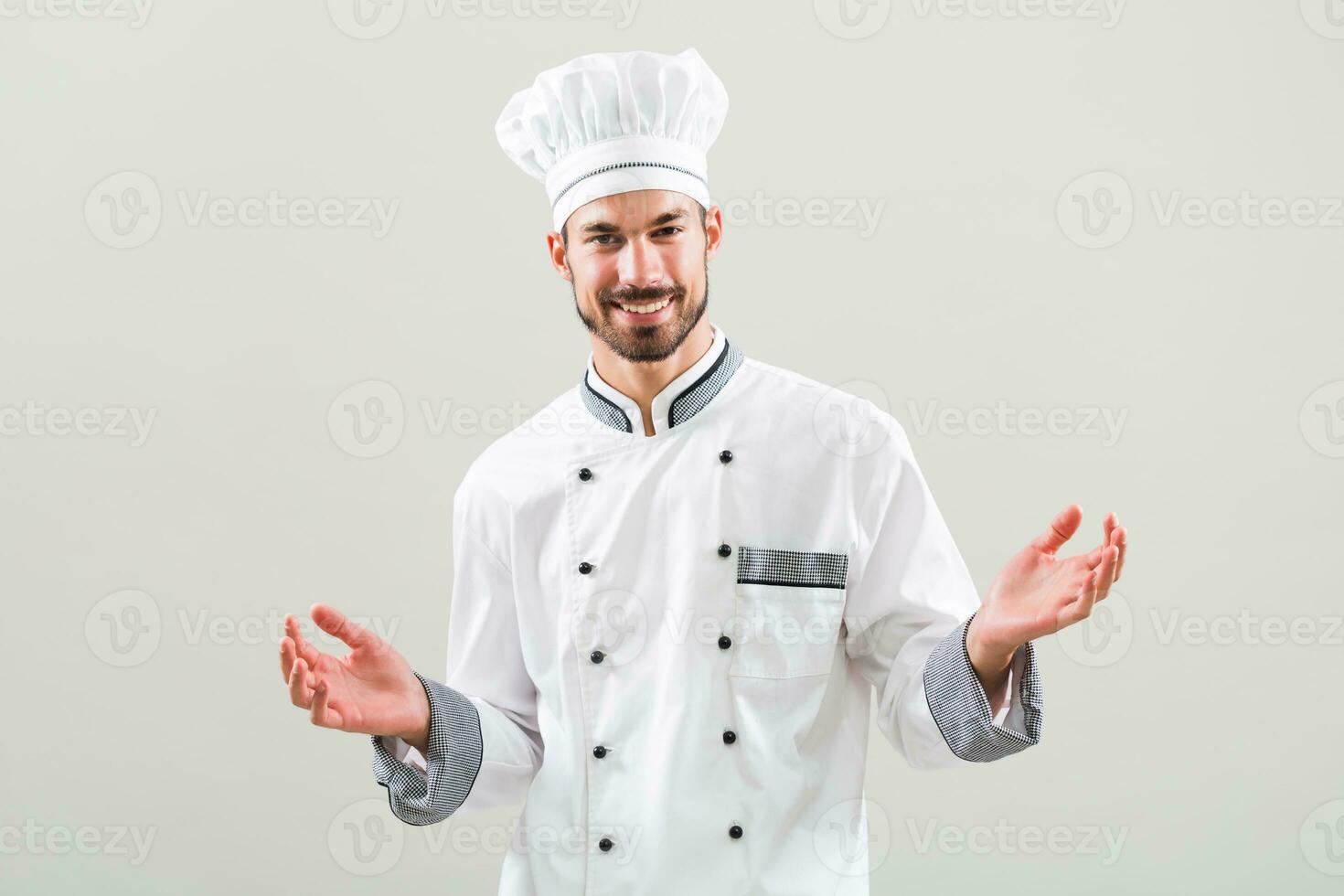 Chef smiling and gesturing on gray background photo