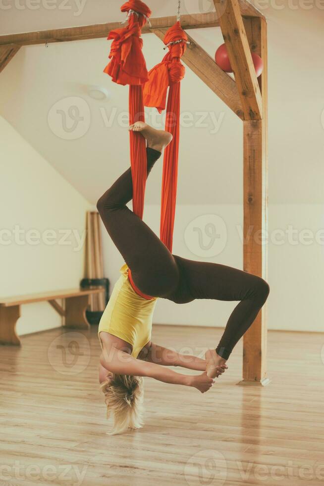 Woman doing aerial yoga in the fitness studio photo