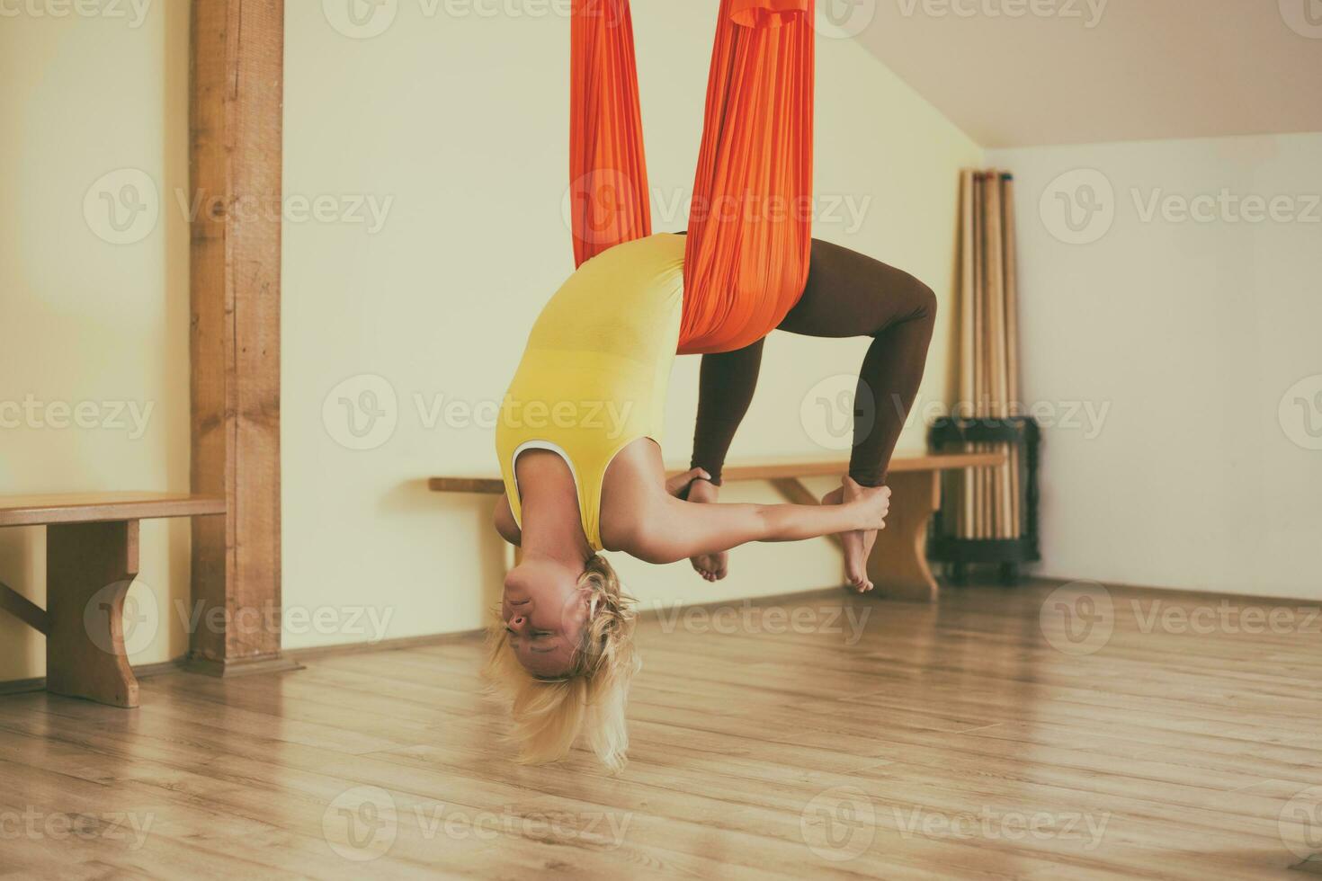 Woman doing aerial yoga in the fitness studio photo