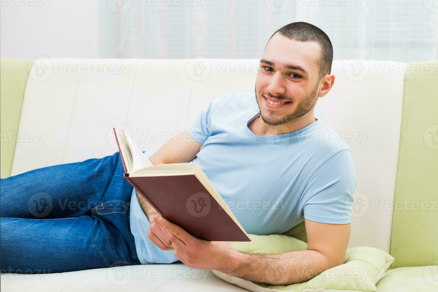 joven hombre disfruta leyendo libro a su hogar foto