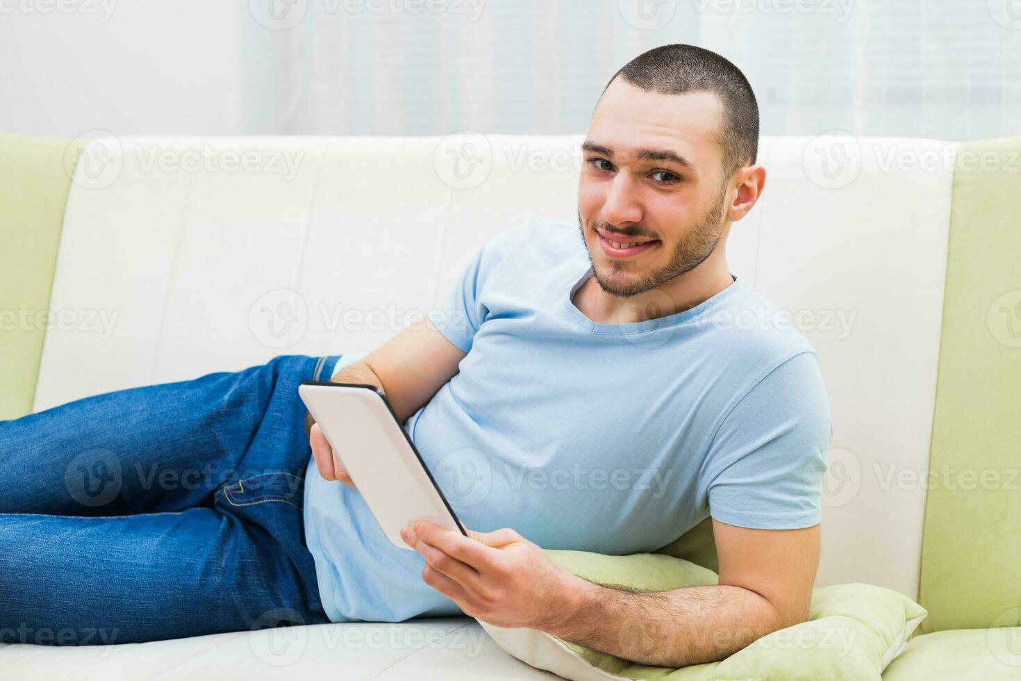Young man using digital tablet at his home photo