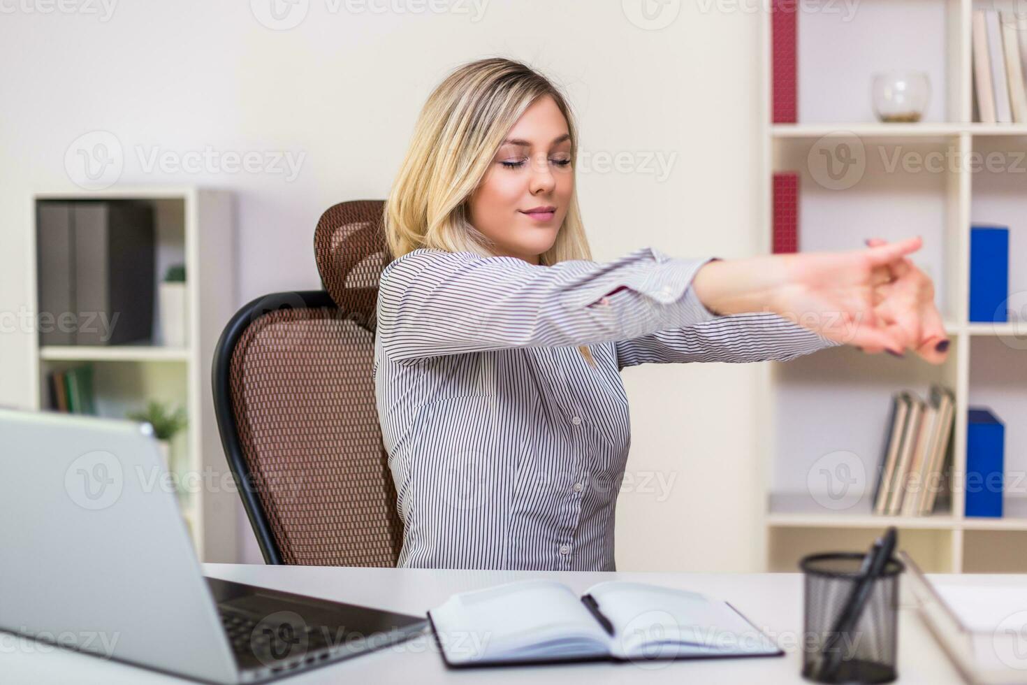 mujer de negocios extensión mientras trabajando en su oficina foto