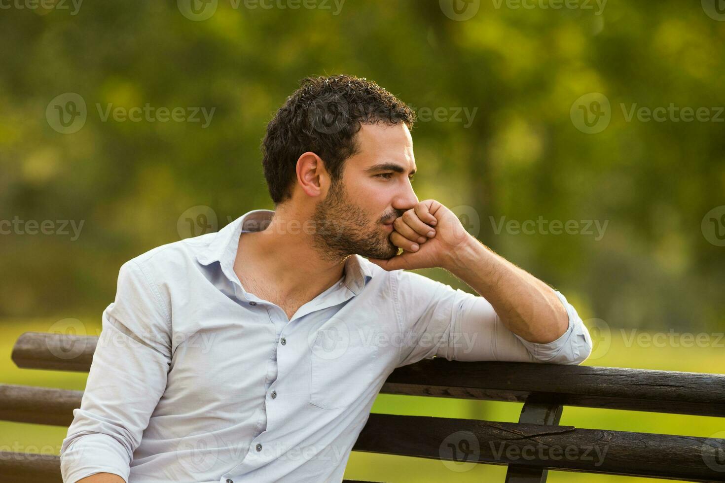 Depressed businessman is sitting at the park and thinking about something photo