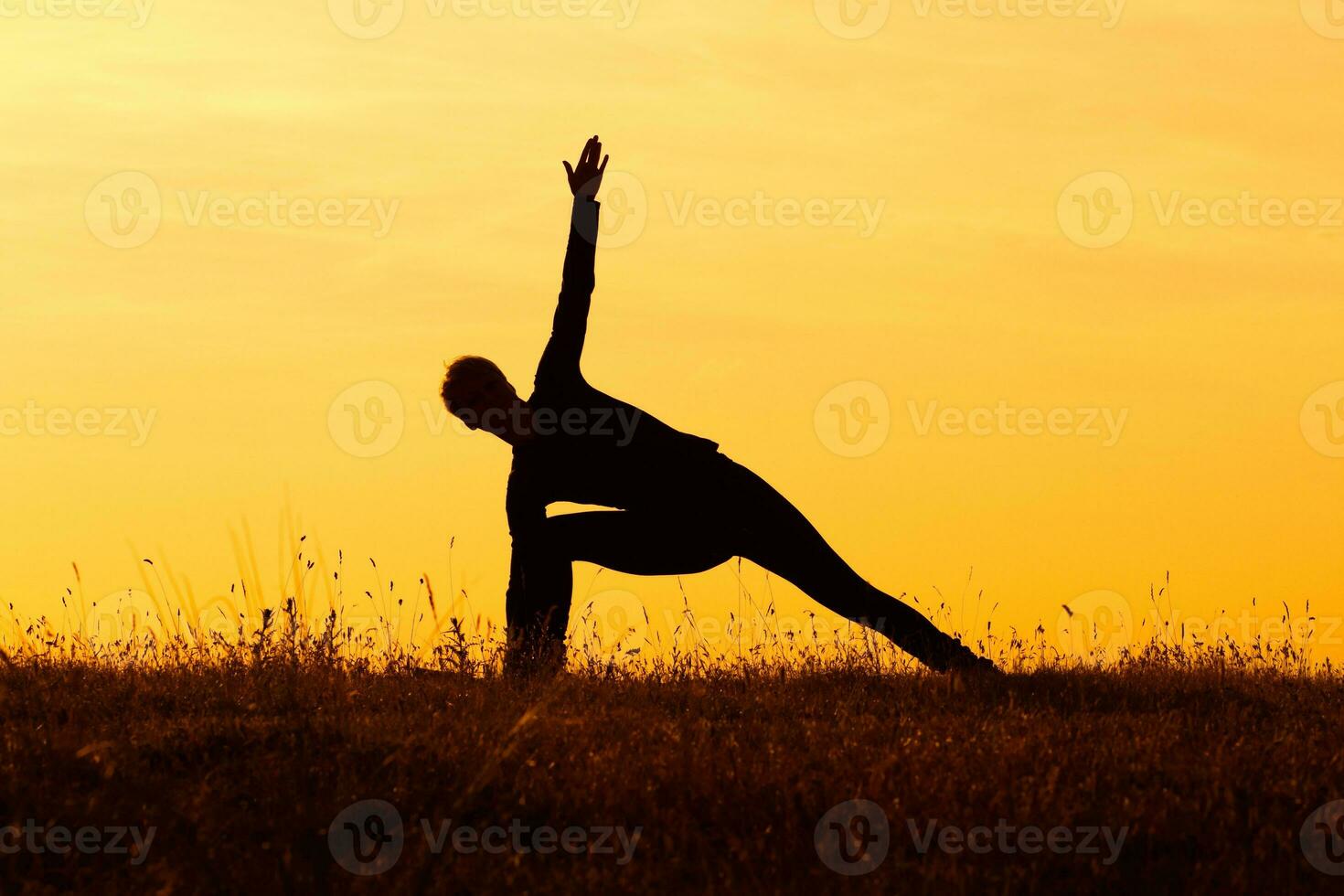 Silhouette of woman doing yoga photo