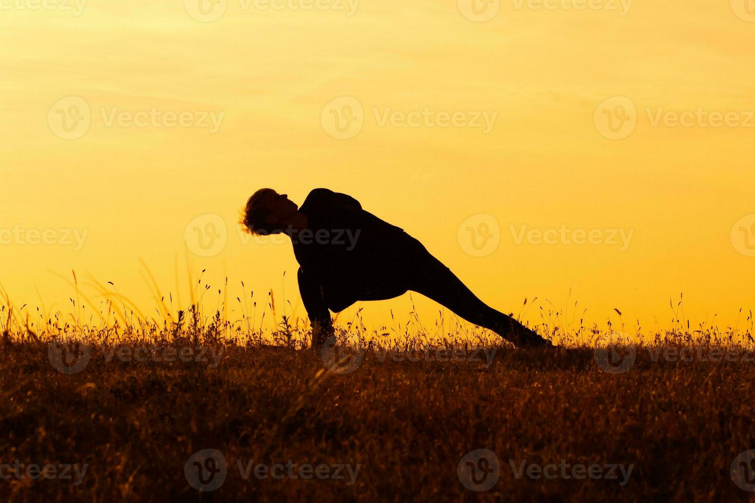 Silhouette of woman doing yoga photo