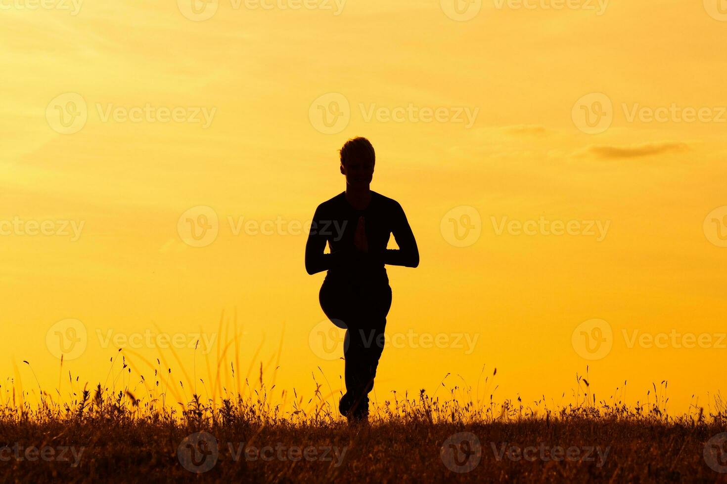 Silhouette of woman doing yoga photo
