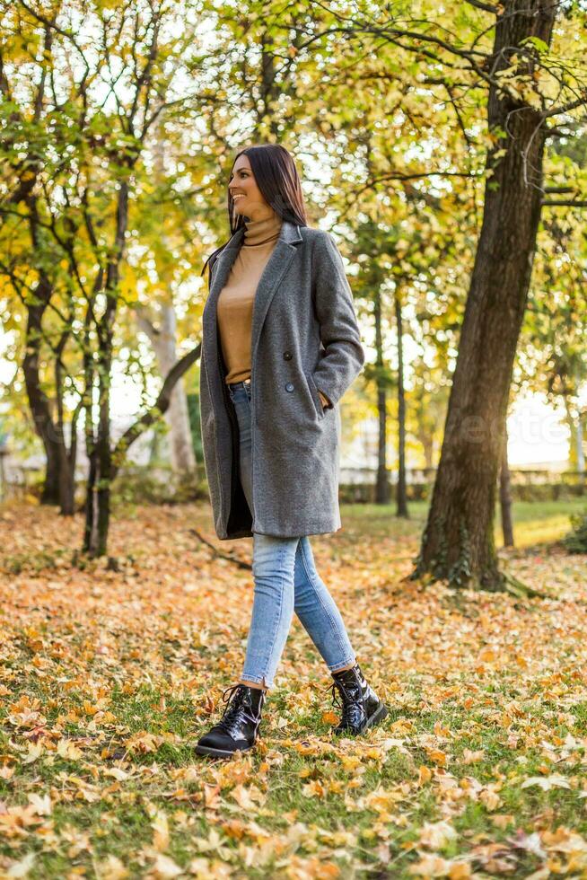 hermosa mujer caminando en el parque y disfruta en otoño. foto