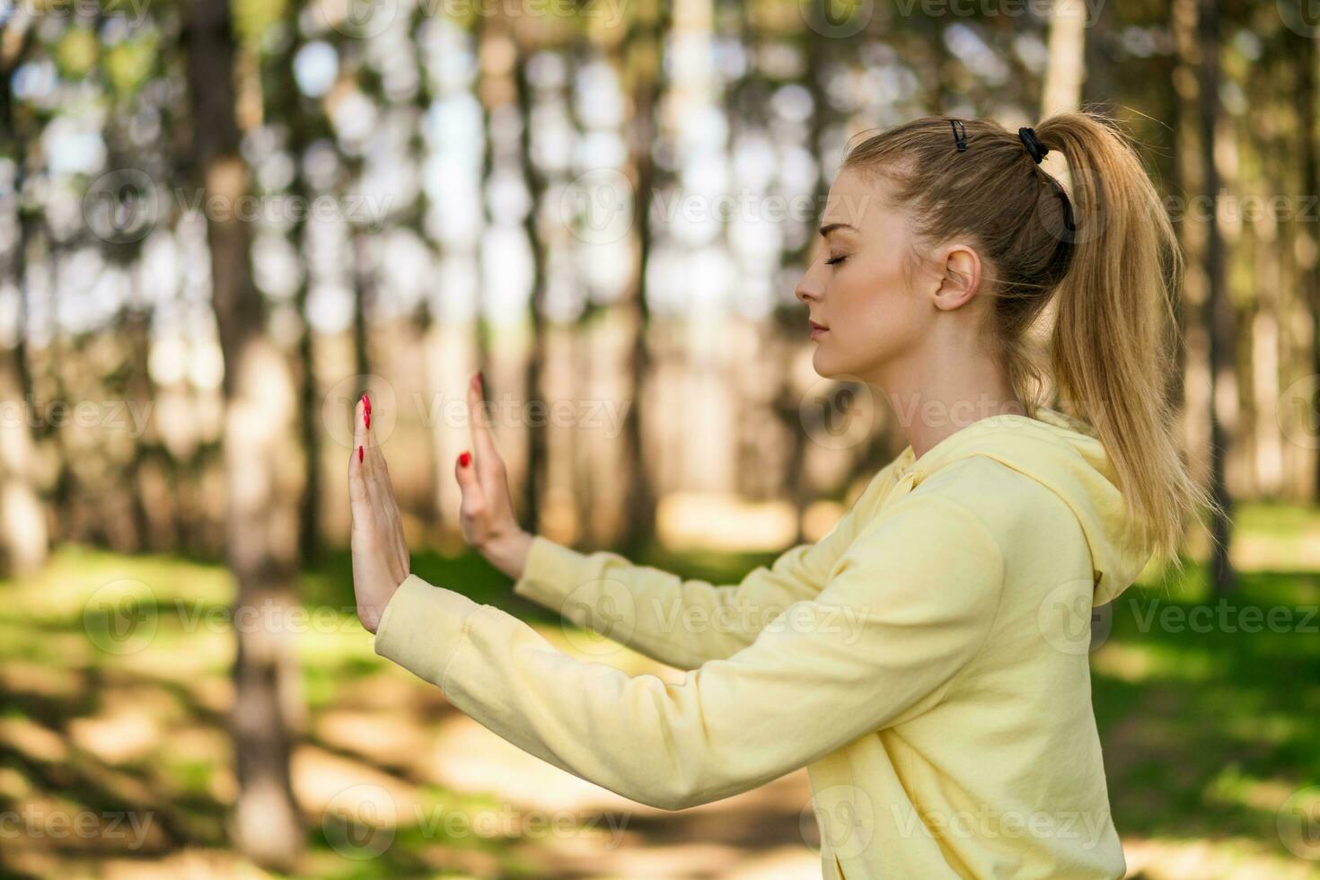 Beautiful woman enjoys exercising Tai Chi in the nature photo
