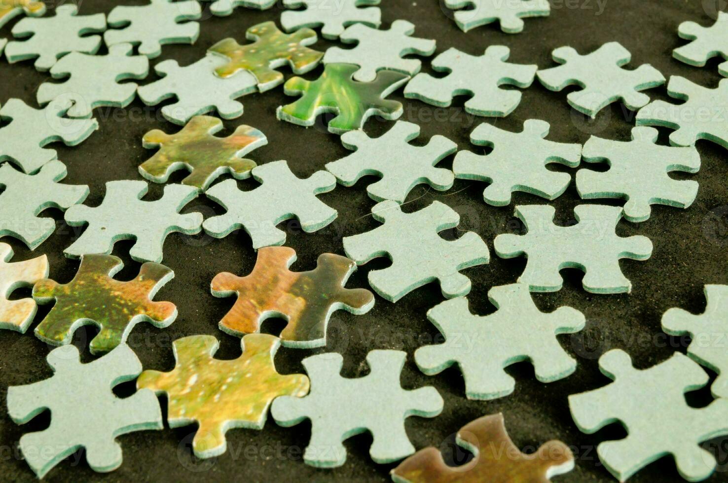 a pile of puzzle pieces on a table photo