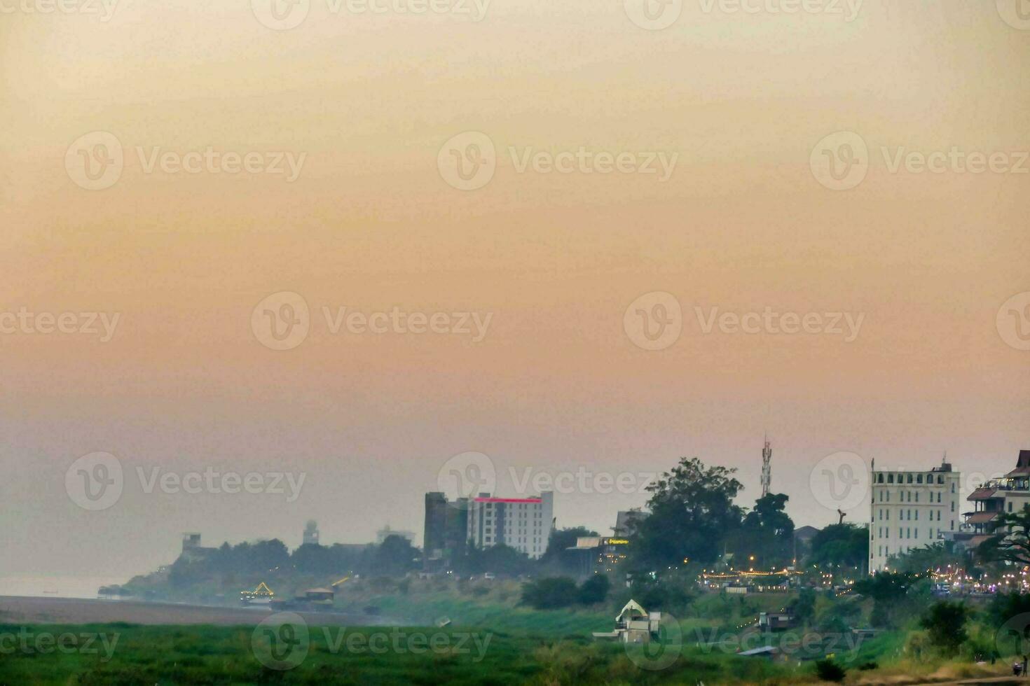 a view of the beach and buildings at sunset photo