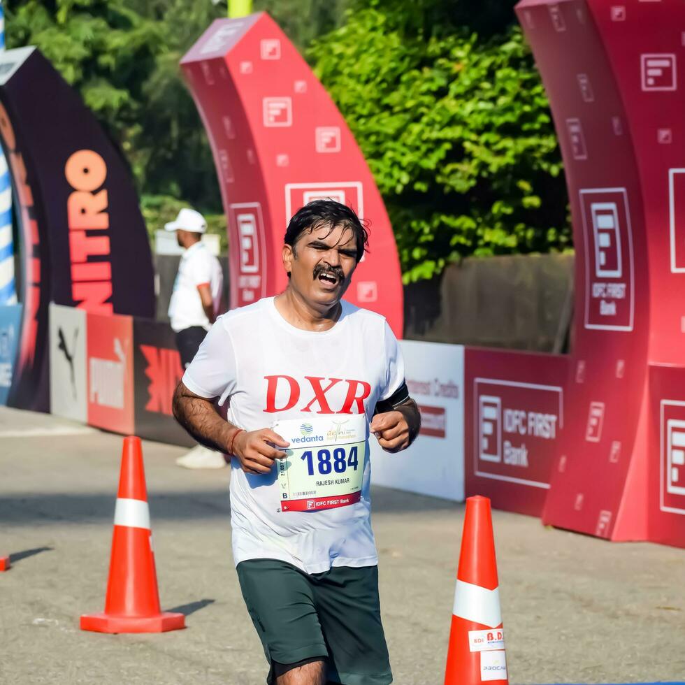 New Delhi, India - October 15 2023 - Vedanta Delhi Half Marathon race after covid in which marathon participants about to cross the finish line, Delhi Half Marathon 2023 photo