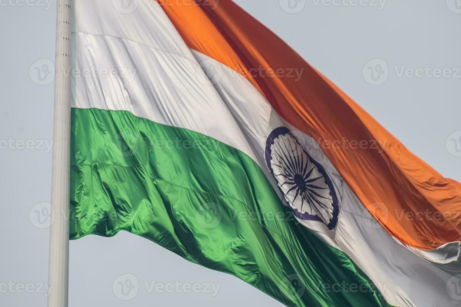 India flag flying high at Connaught Place with pride in blue sky, India flag fluttering, Indian Flag on Independence Day and Republic Day of India, tilt up shot, Waving Indian flag, Har Ghar Tiranga photo