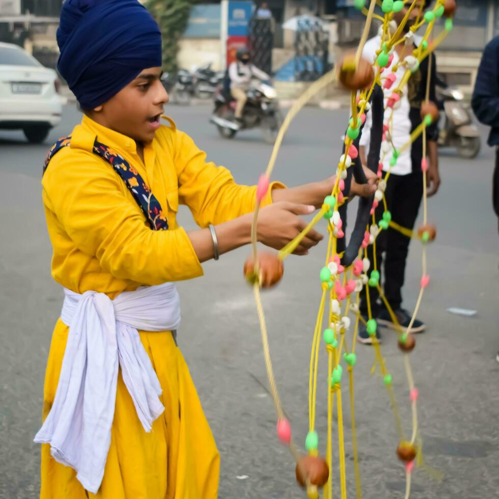 Delhi, India, October 2, 2023 - Sikhs display gatka and martial arts during annual Nagar Kirtan, Traditional, procession on account of birthday of Guru Nanak Dev ji, Nagar Kirtan in East Delhi area photo
