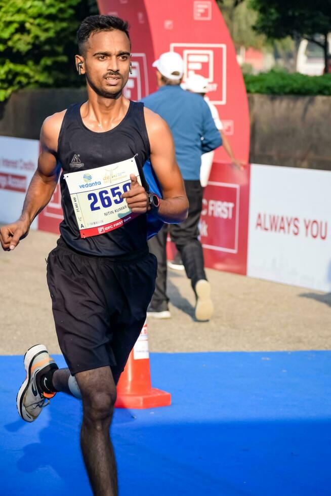 New Delhi, India - October 15 2023 - Vedanta Delhi Half Marathon race after covid in which marathon participants about to cross the finish line, Delhi Half Marathon 2023 photo