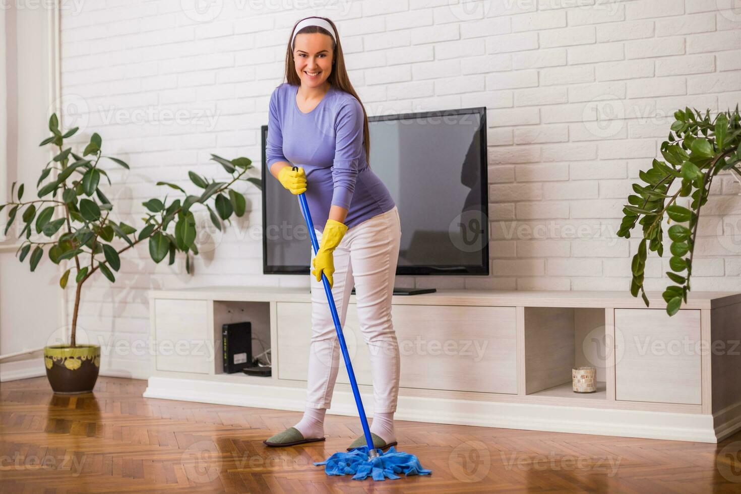 hermosa embarazada mujer disfruta limpieza su casa. foto