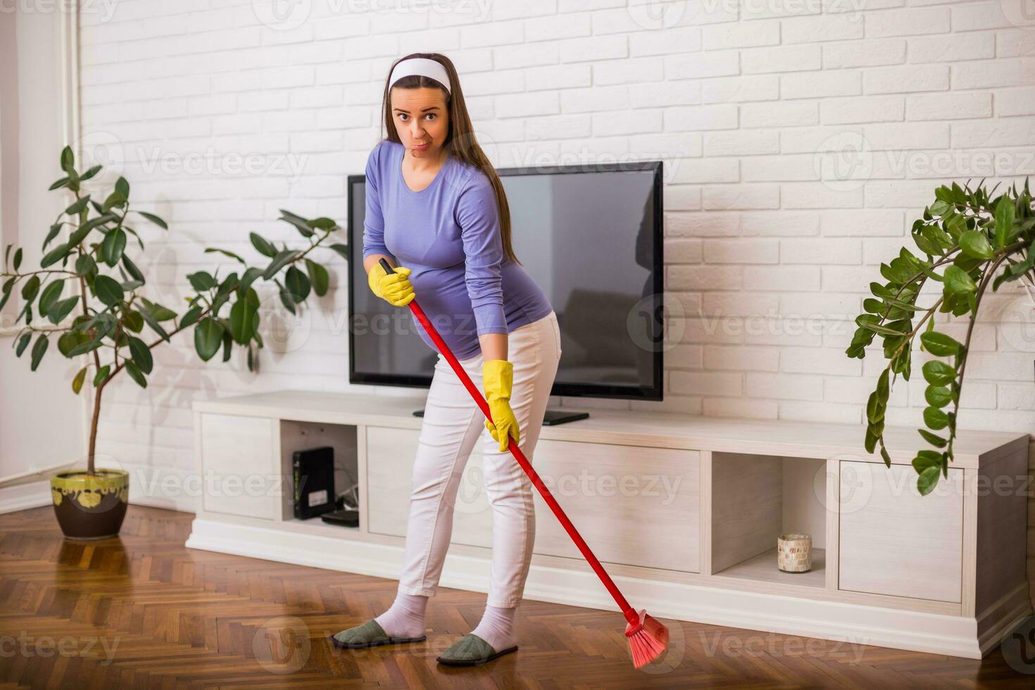 Tired pregnant woman having pain in back while she is  cleaning her house. photo