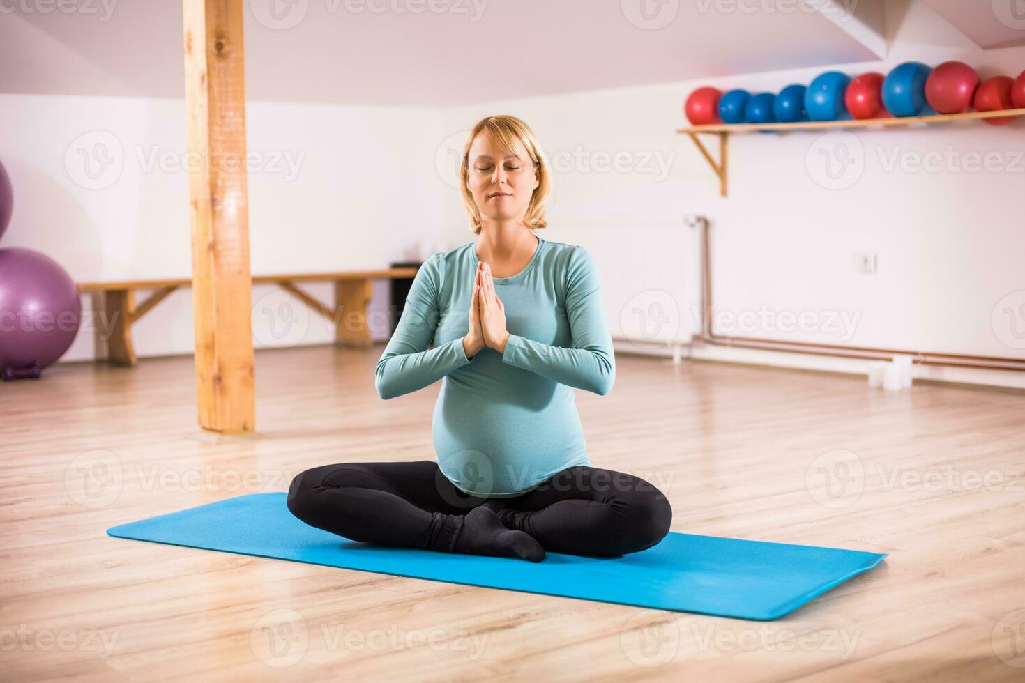 Pregnant woman enjoys meditating photo