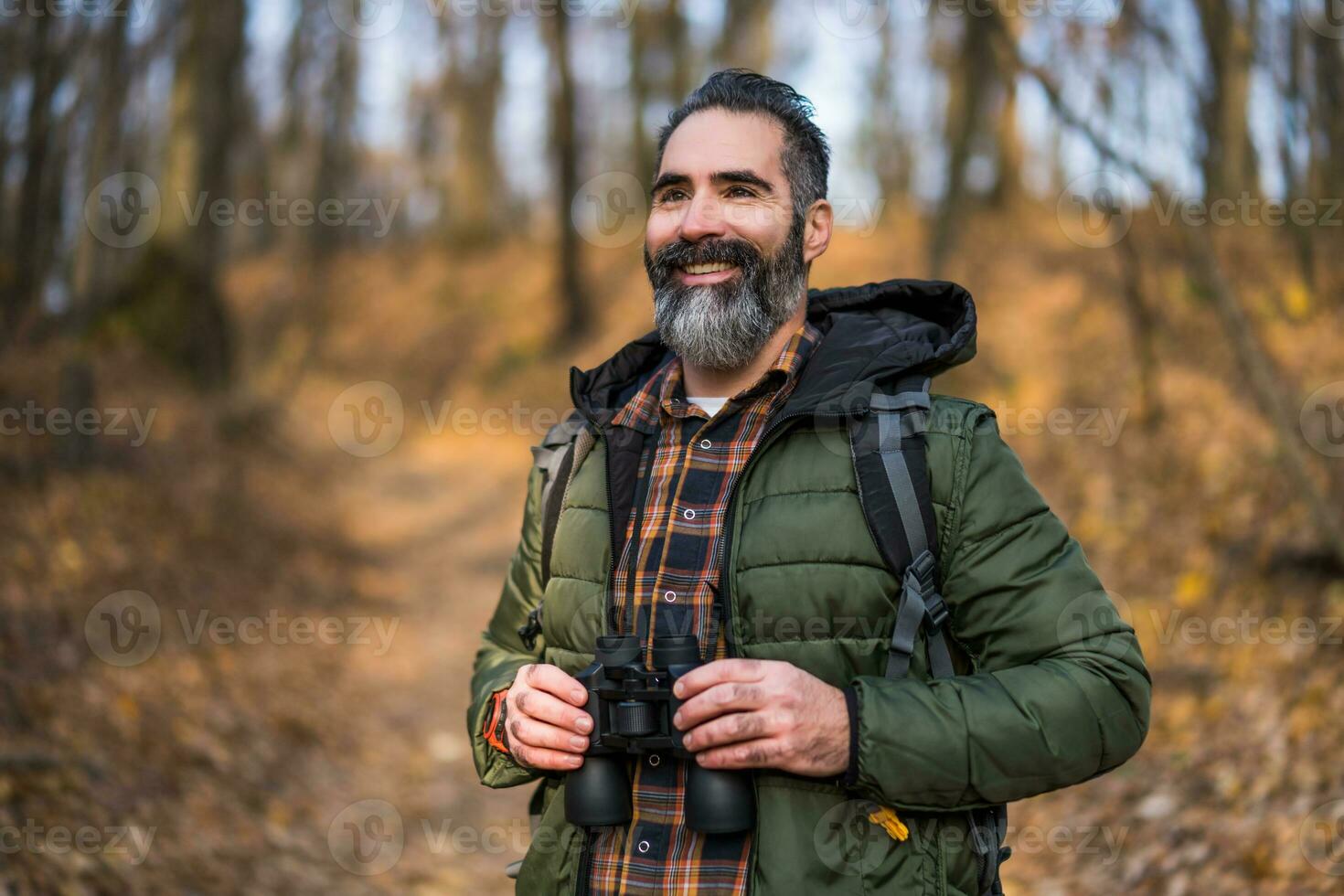 Image of man hiking and using binoculars photo