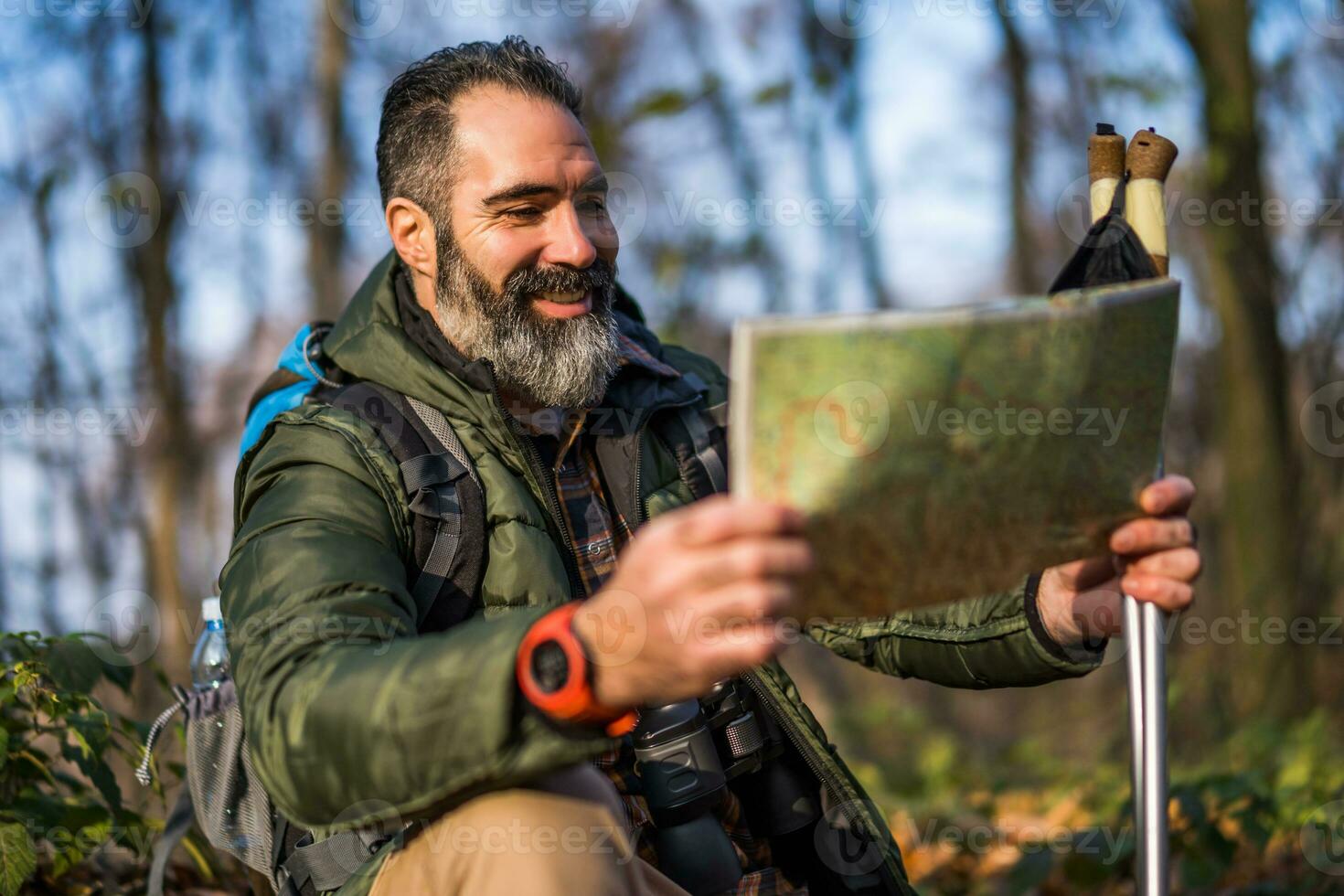 imagen de caminante sentado en naturaleza y mirando a mapa foto