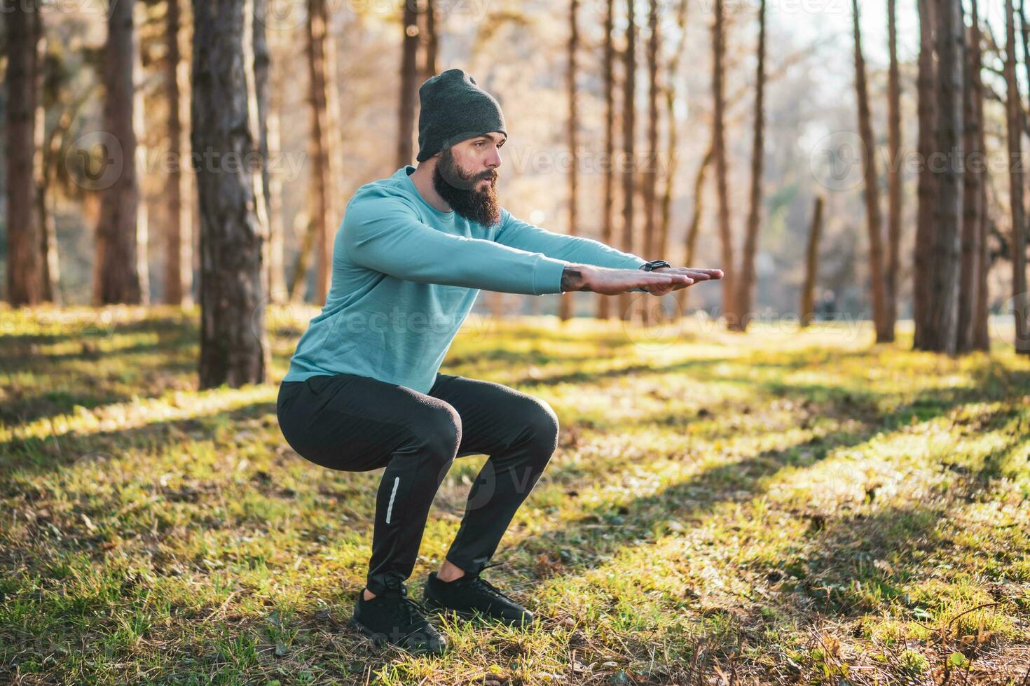 Man with beard enjoys exercising in nature photo