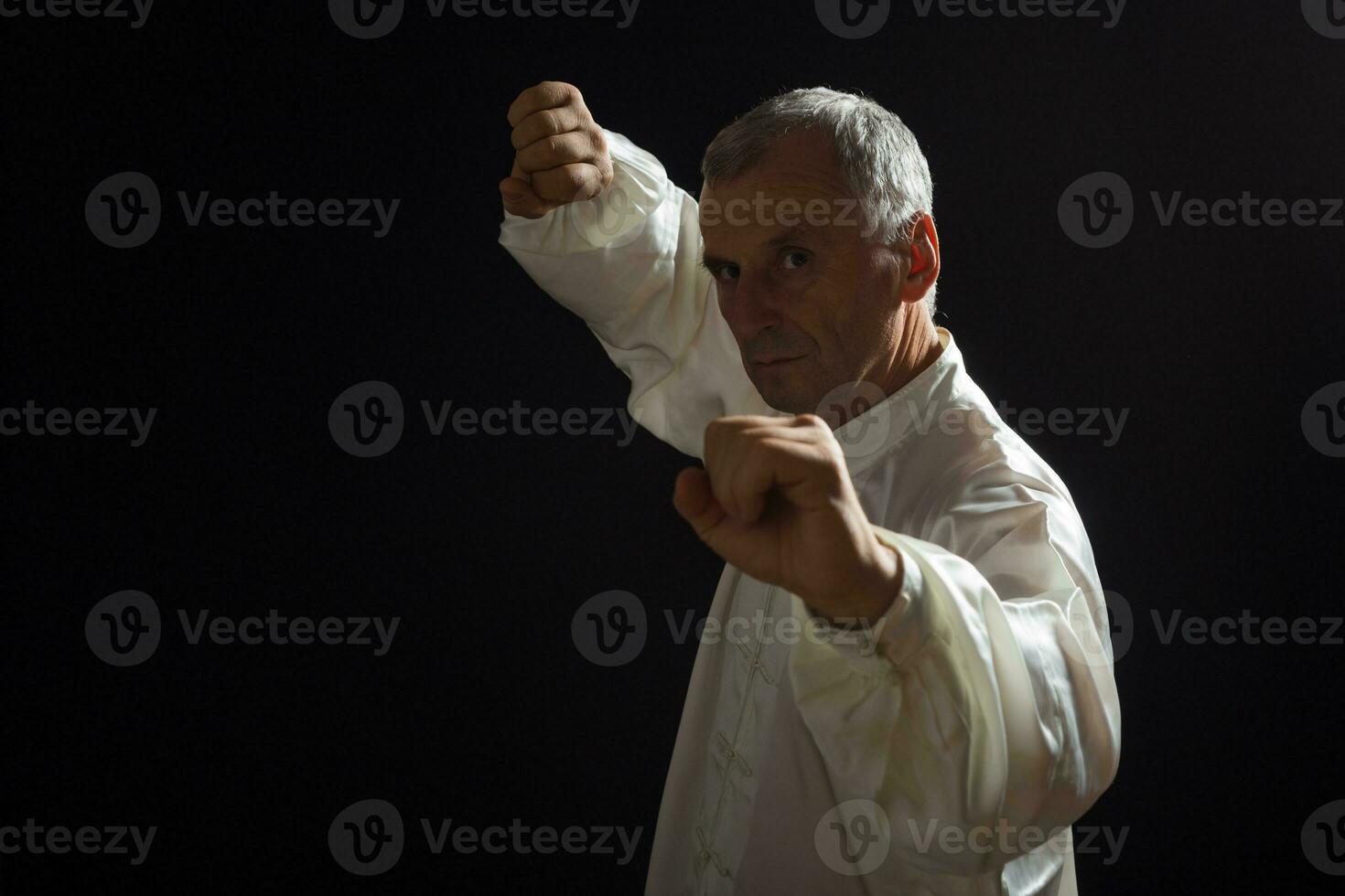 Senior man enjoys exercise Tai Chi indoor photo