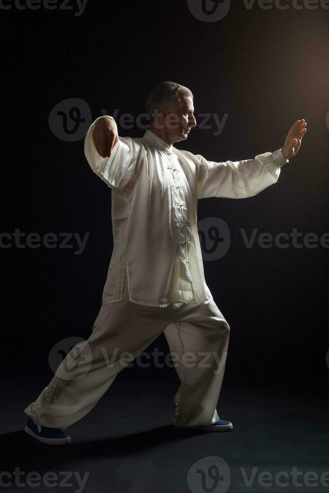 Senior man enjoys exercise Tai Chi indoor photo