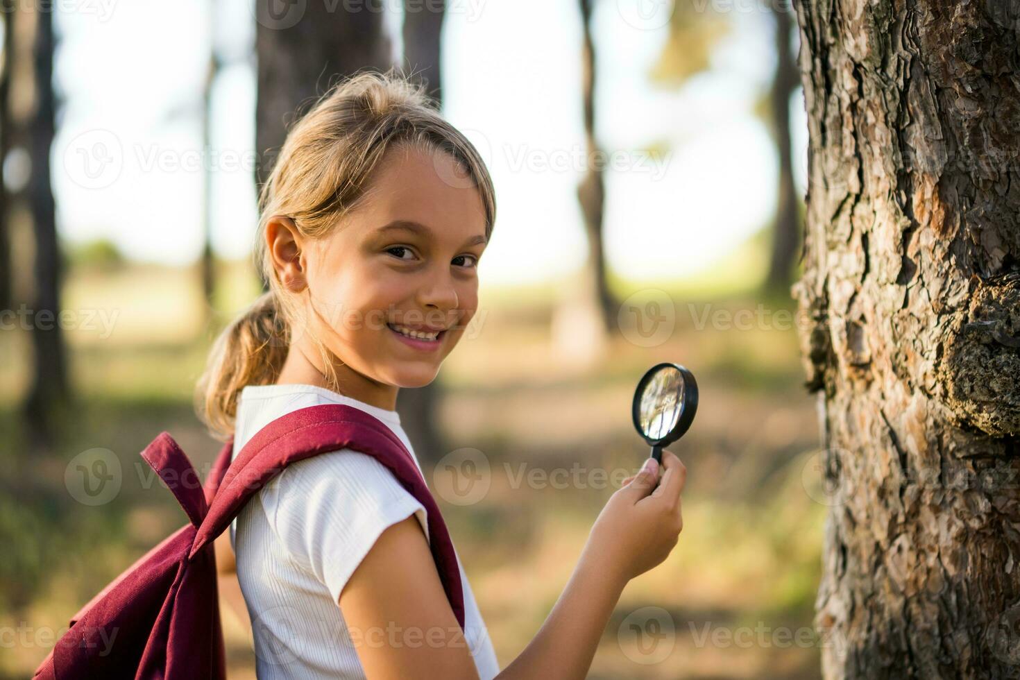 Little girl explore with magnifying glass nature photo