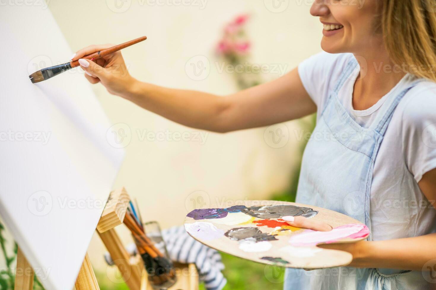 Woman enjoys woman painting on canvas outdoor photo