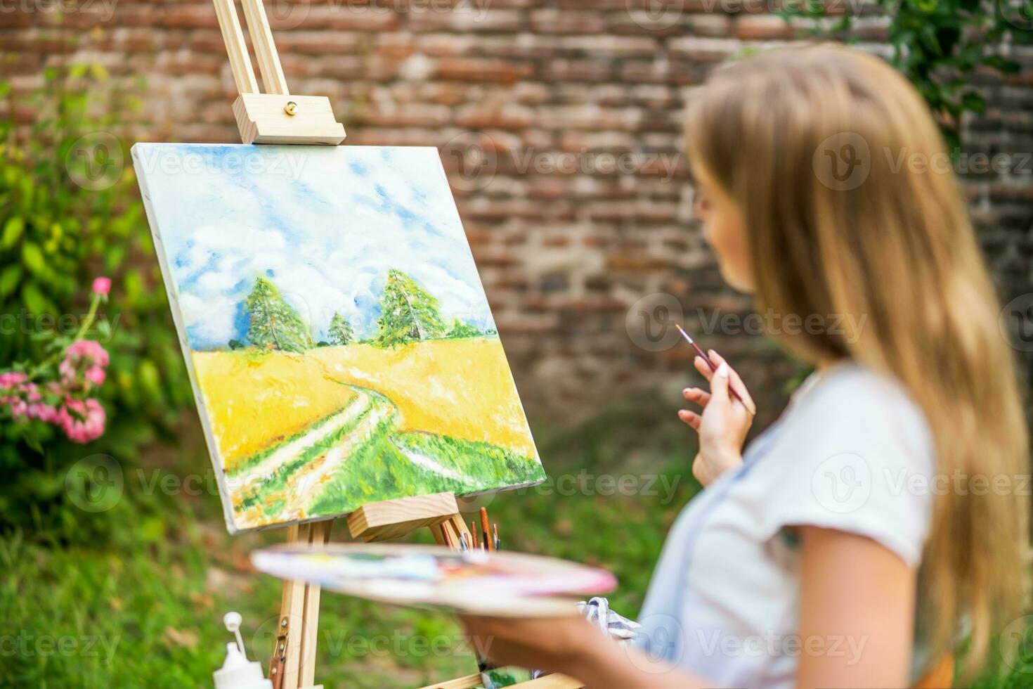 Woman enjoys woman painting on canvas outdoor photo