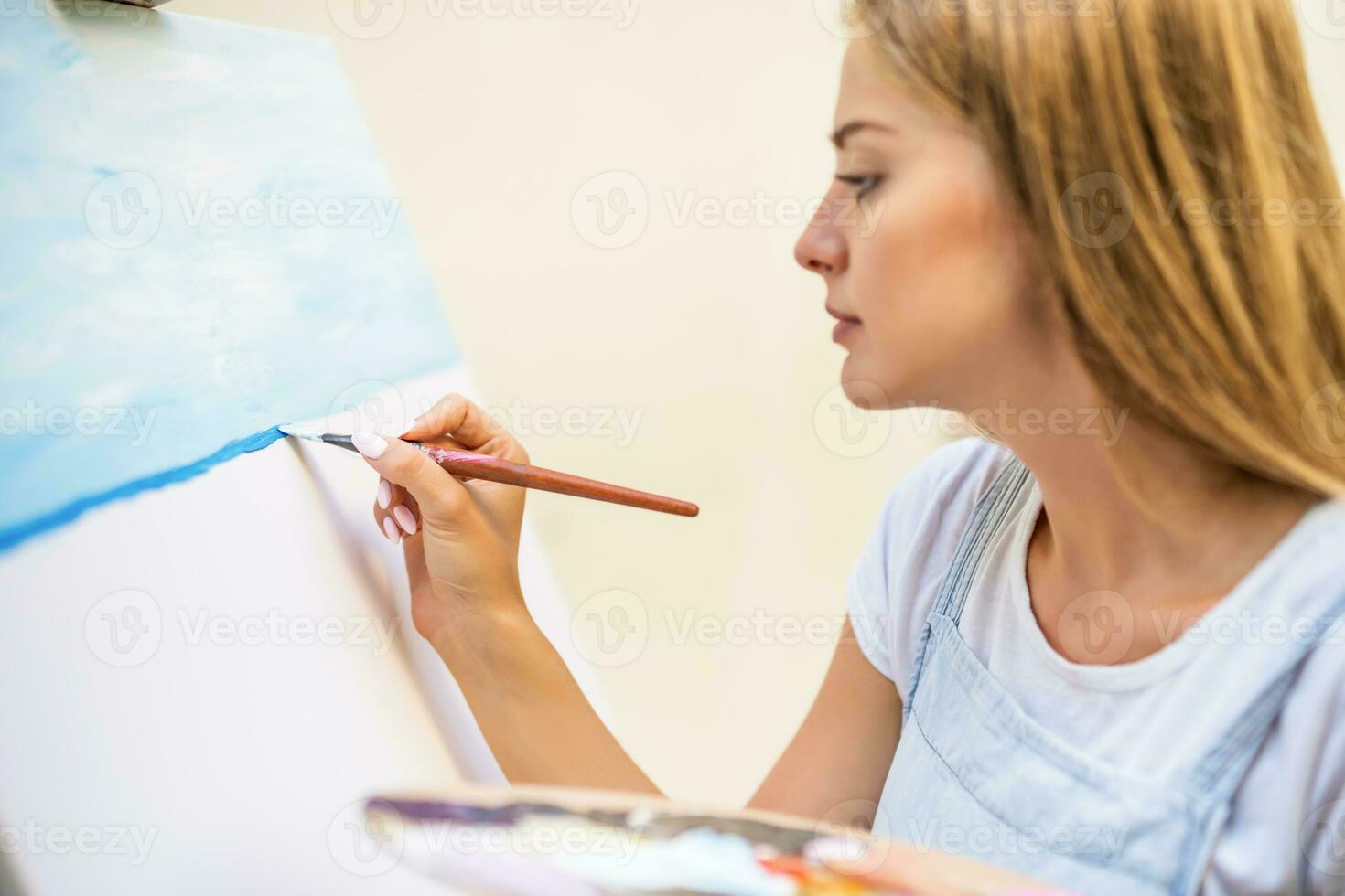 Woman enjoys woman painting on canvas outdoor photo