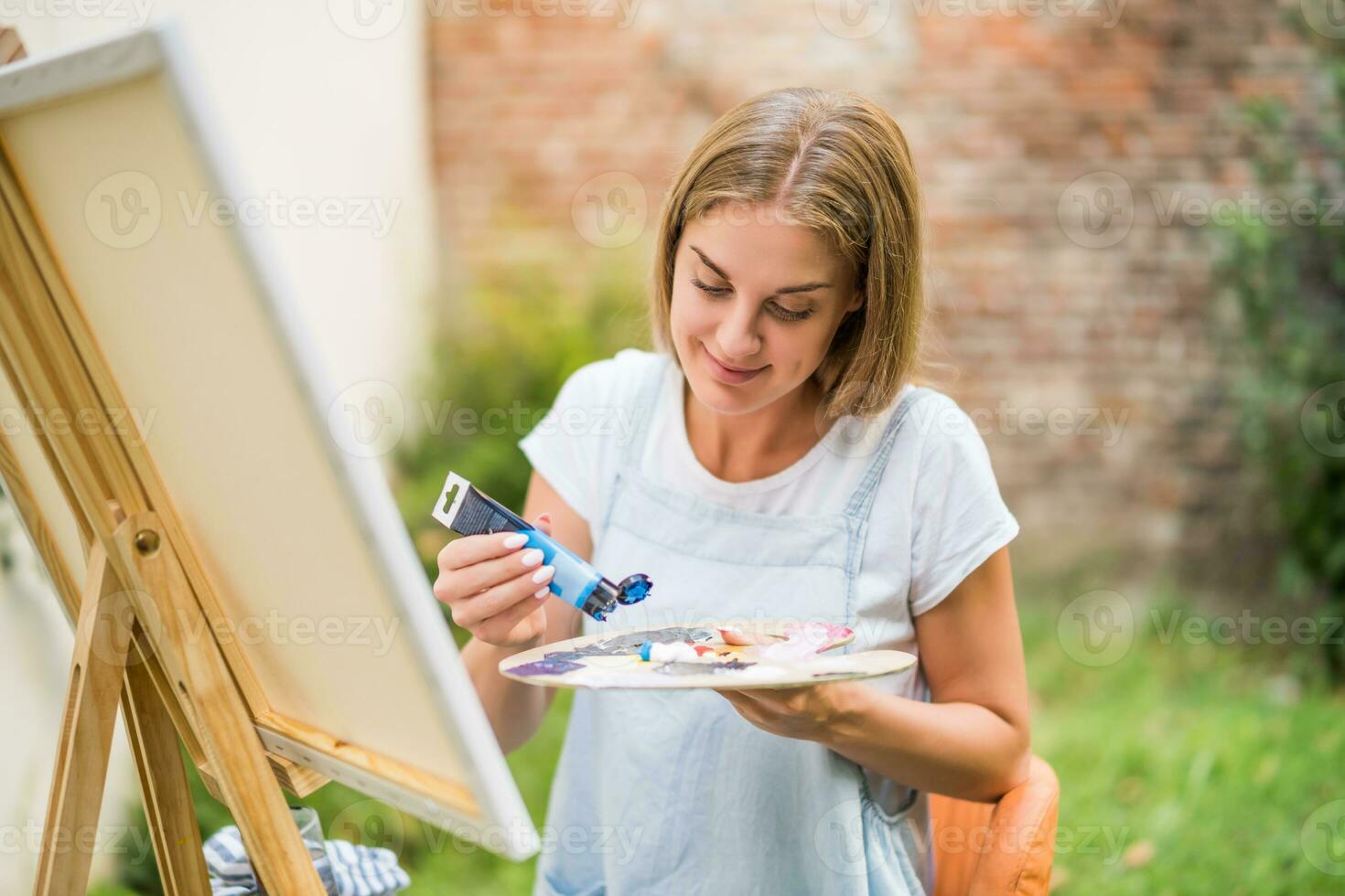 Woman enjoys woman painting on canvas outdoor photo