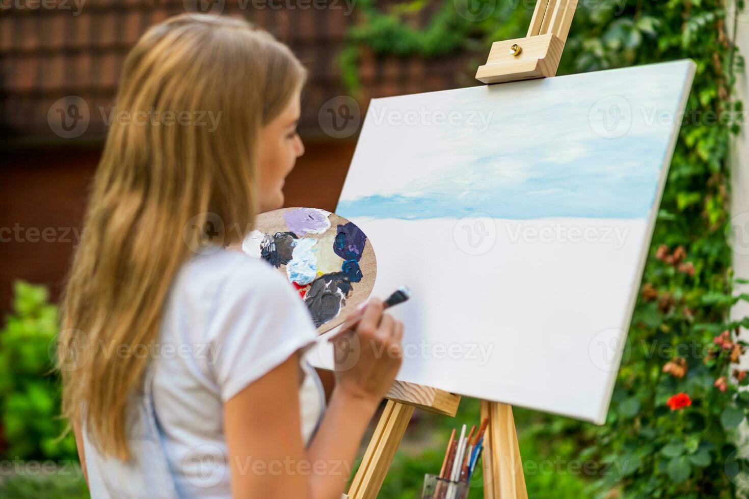 Woman enjoys woman painting on canvas outdoor photo