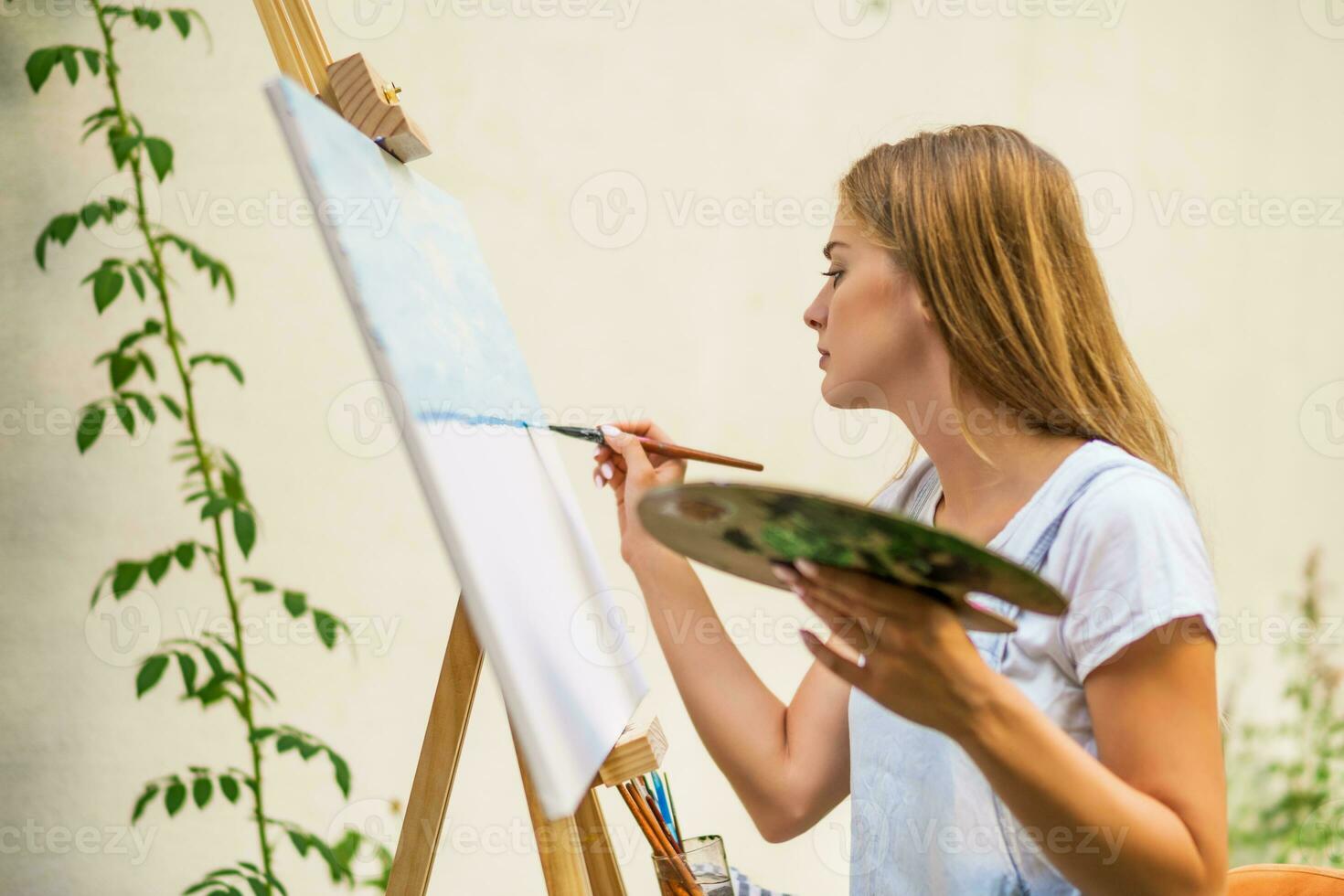 Woman enjoys woman painting on canvas outdoor photo