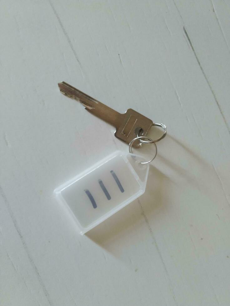 Key on the keychain in the form of a house on a white background photo