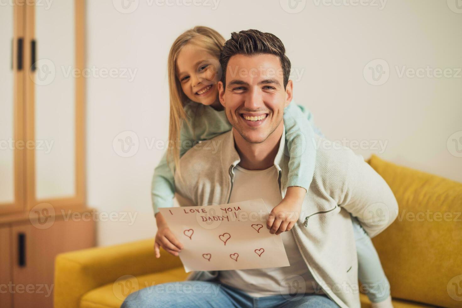 Happy father and daughter holding greeting card with heart shapes and text. Father's day concept. photo