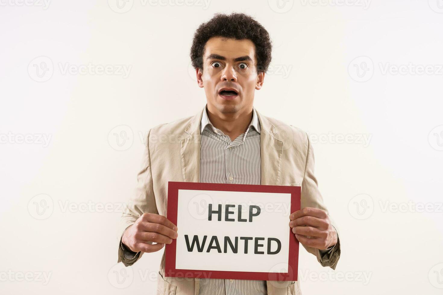Businessman in panic holding paper with text help wanted photo