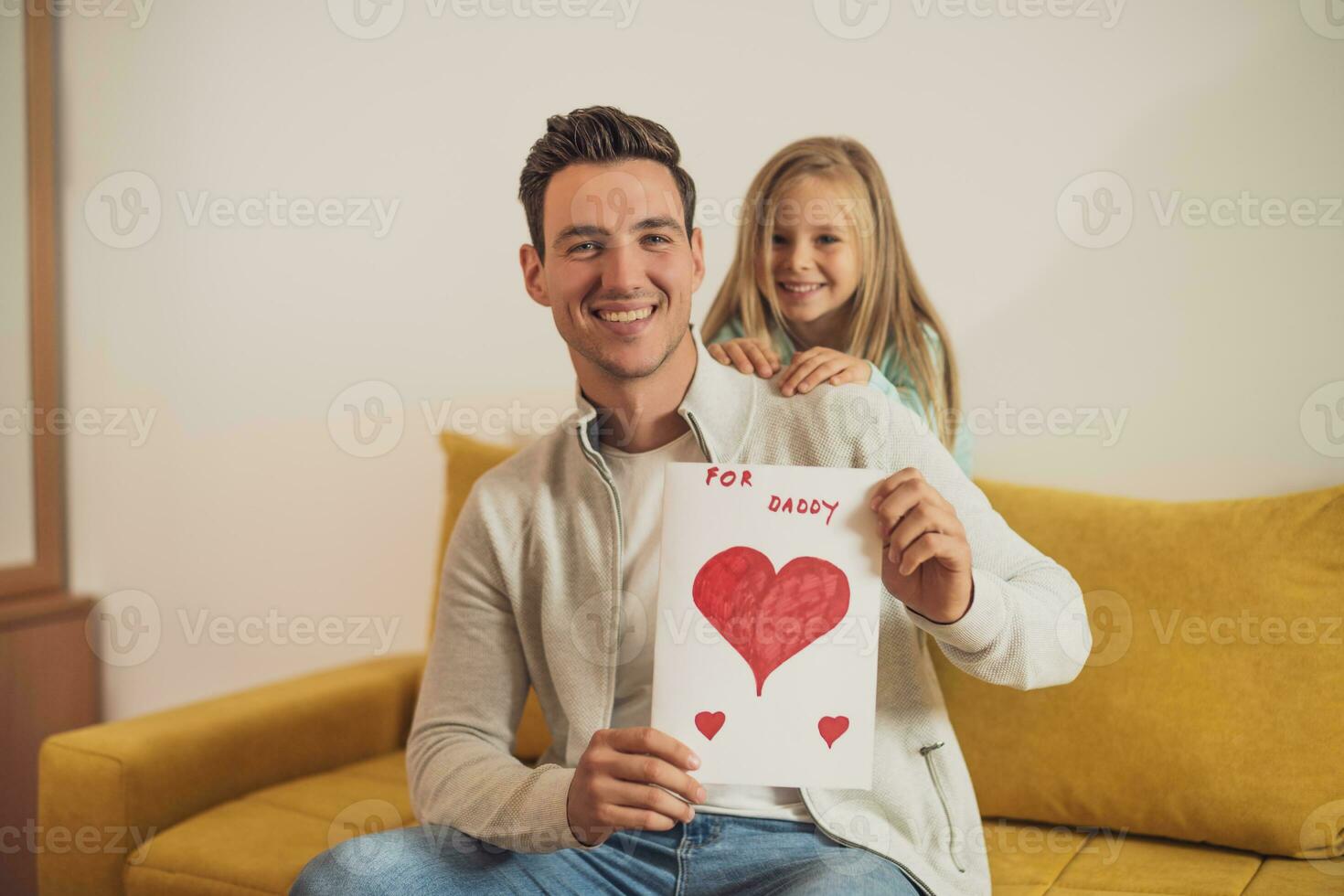 Happy father and daughter holding greeting card with heart shapes and text. Father's day concept. photo