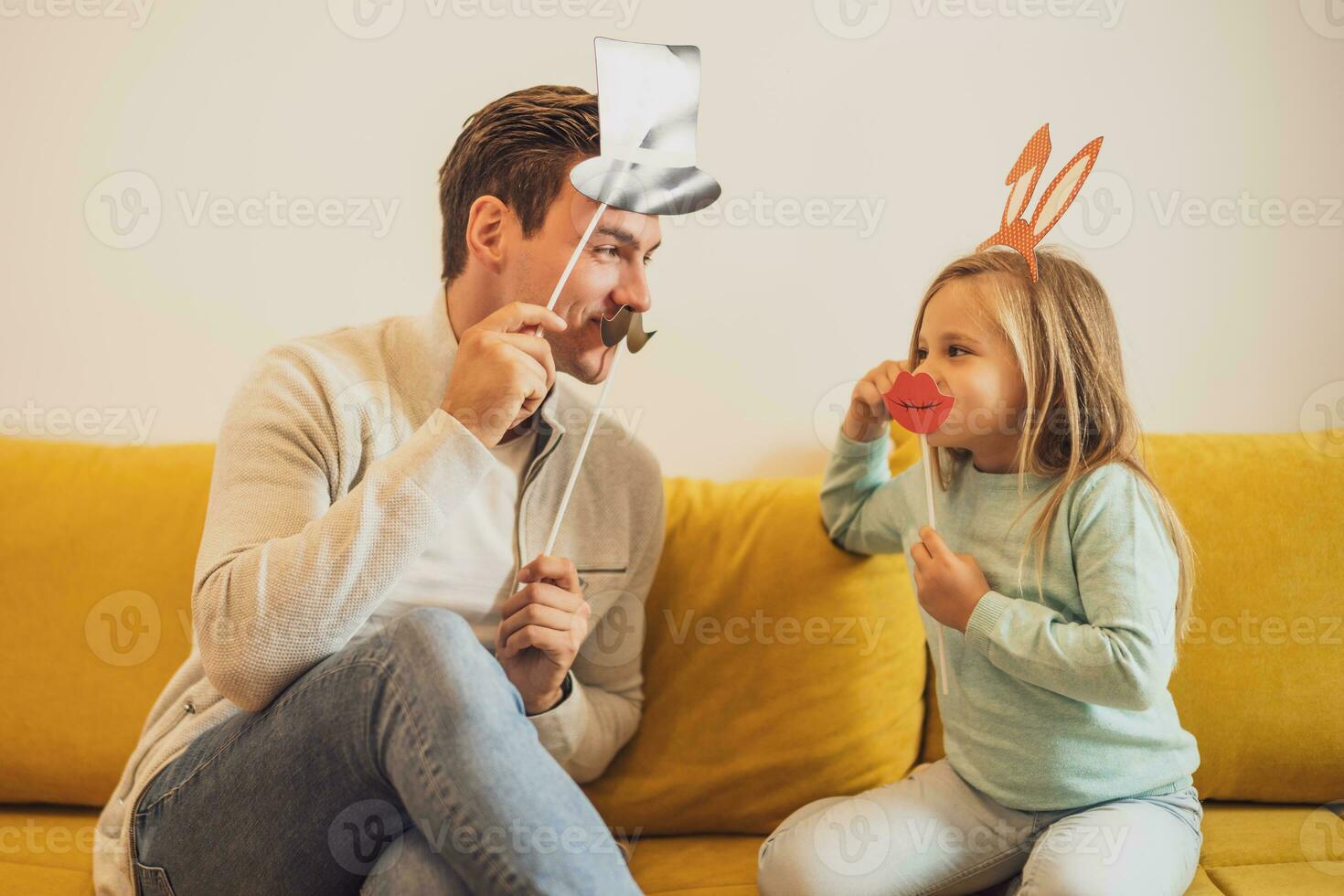 Father and daughter having fun with party props at their home photo