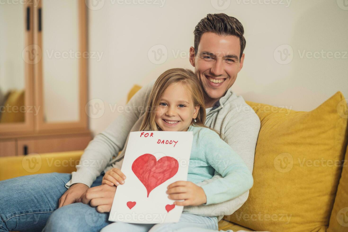 Happy father and daughter holding greeting card with heart shapes and text. Father's day concept. photo