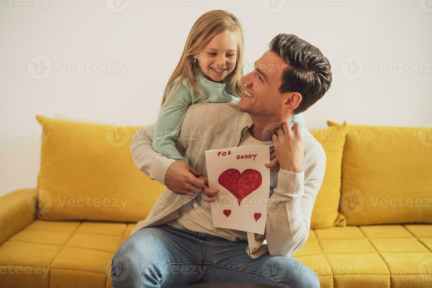 Happy father and daughter holding greeting card with heart shapes and text. Father's day concept. photo